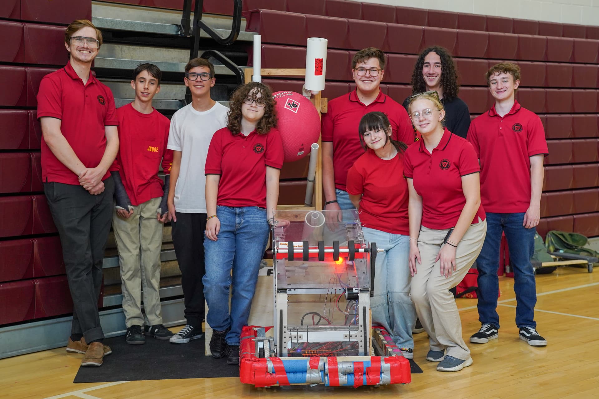 Equipo de robótica con su robot de competencia